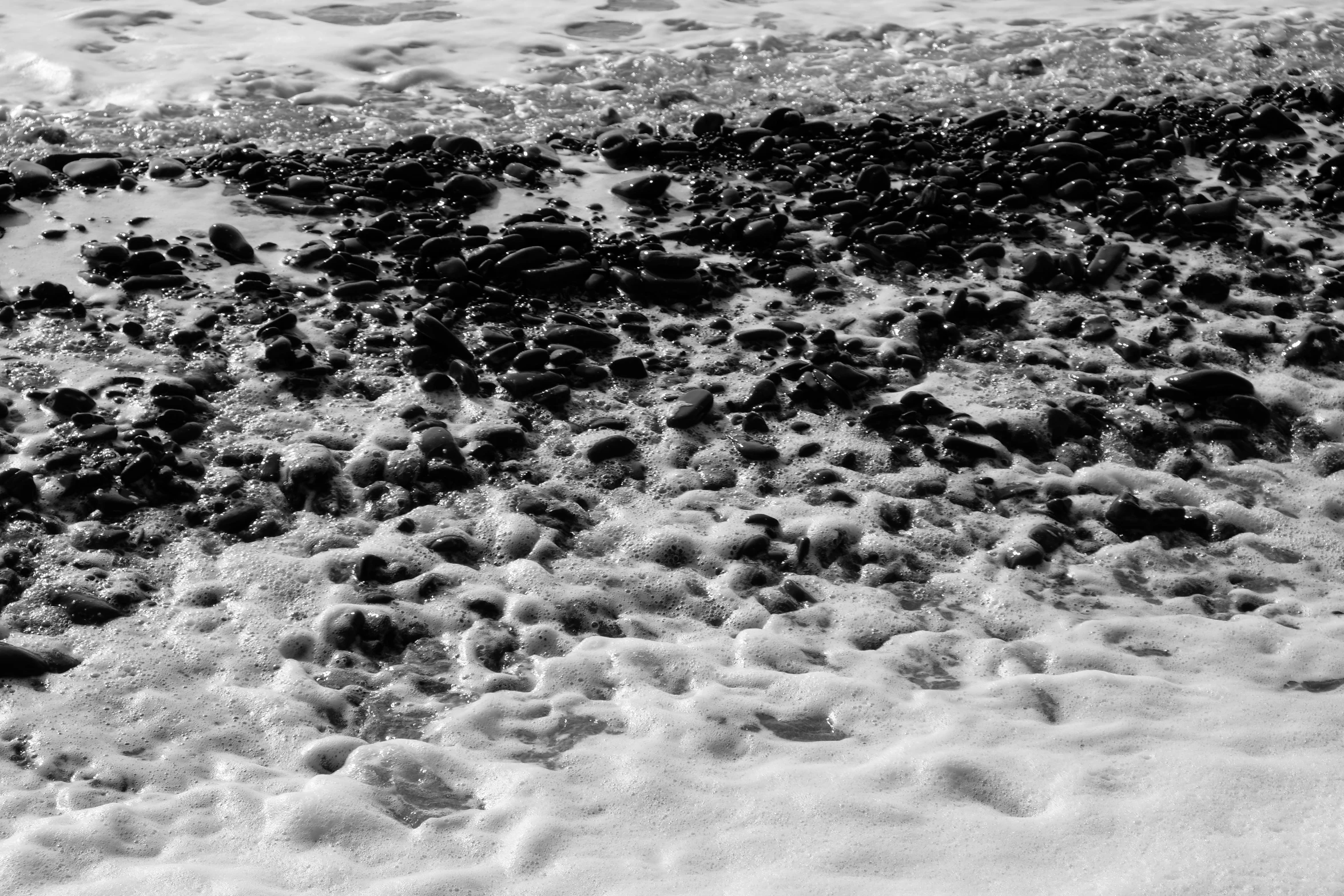 a surf board on the sand by the water