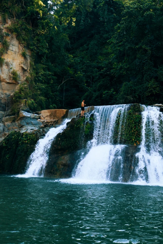 people sitting at the bottom of a waterfall