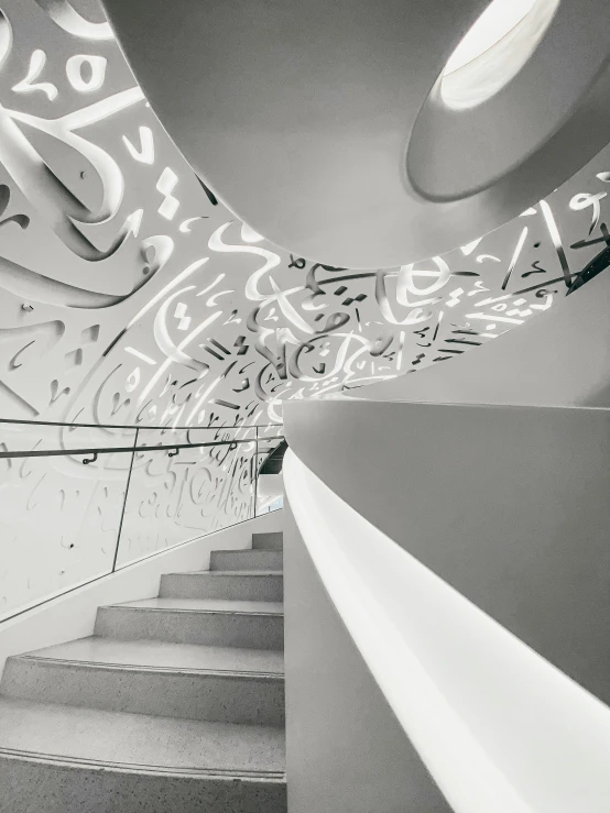 a staircase with arabic writing and lighting above