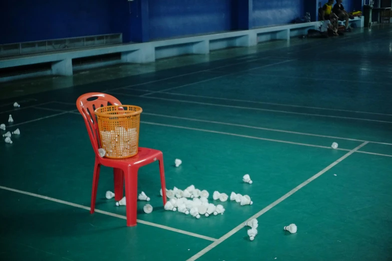 a red chair next to a large pile of cotton balls