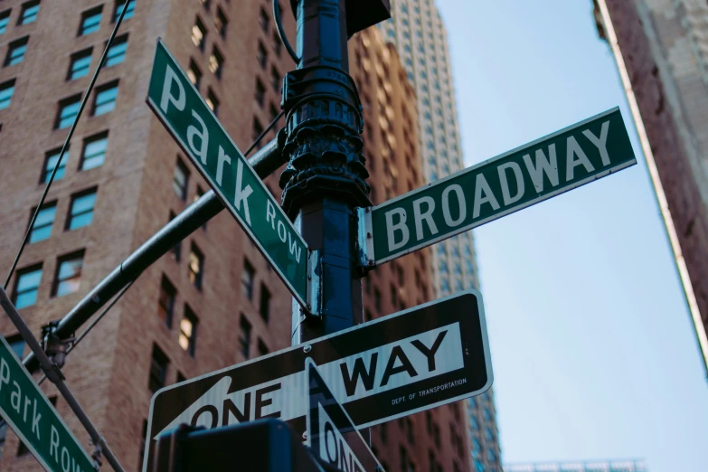 four different street signs are on a pole