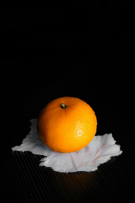 an orange sitting on top of a table on paper towels