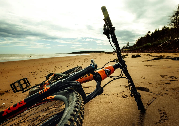 bike leaning against post laying on the beach