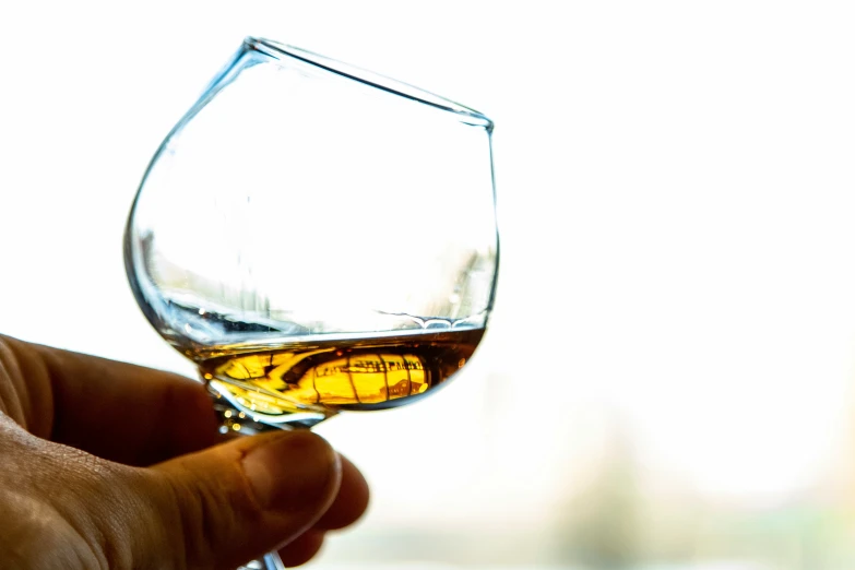 a person holding onto a glass with a liquid in it