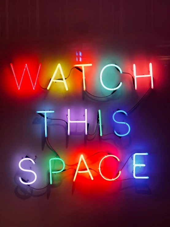 a neon sign with the words watch this space written over it