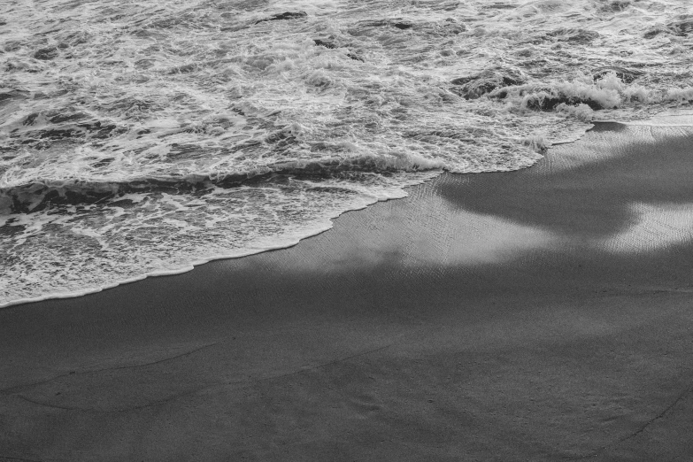 a lone beach umbrella laying on top of the sand