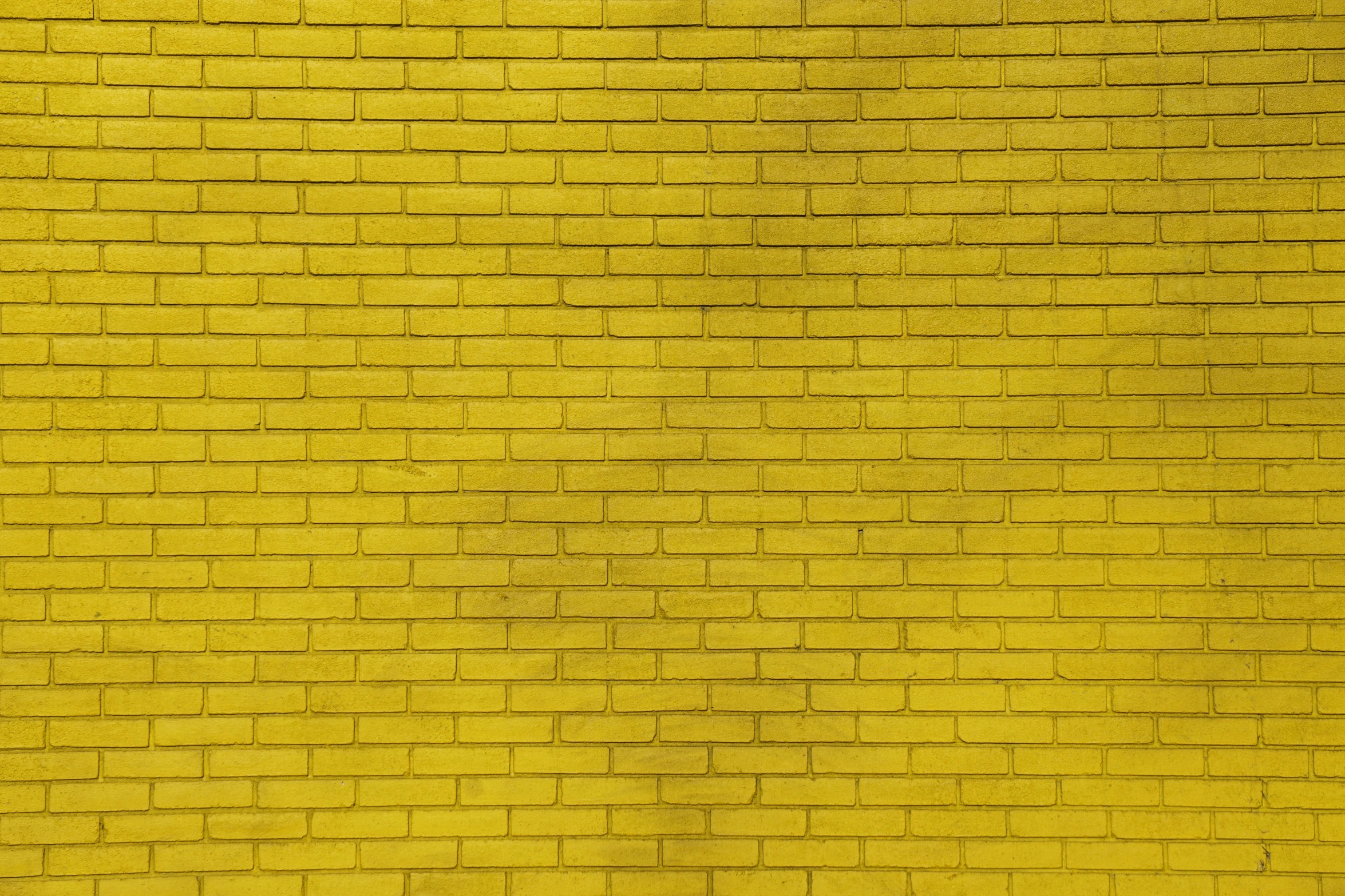 a yellow brick wall with soing green painted on it