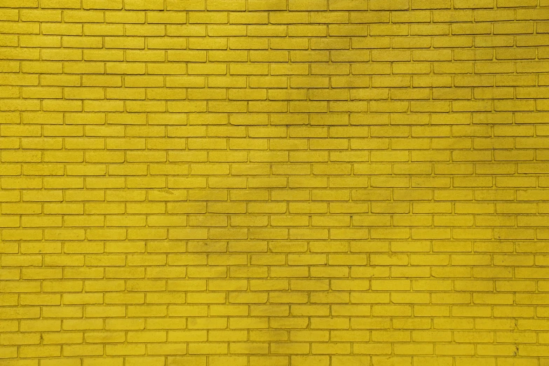 a yellow brick wall with soing green painted on it