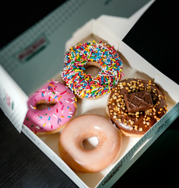 a box of three donuts topped with sprinkles