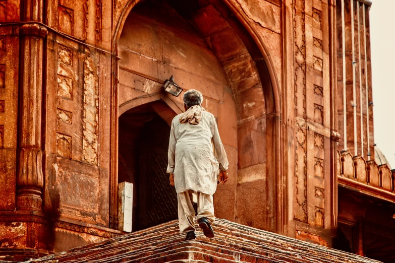 a man walks down the walkway of a tall building