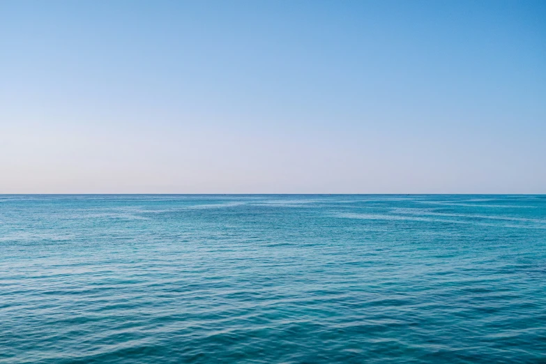 two men sit on a small boat in the middle of blue water