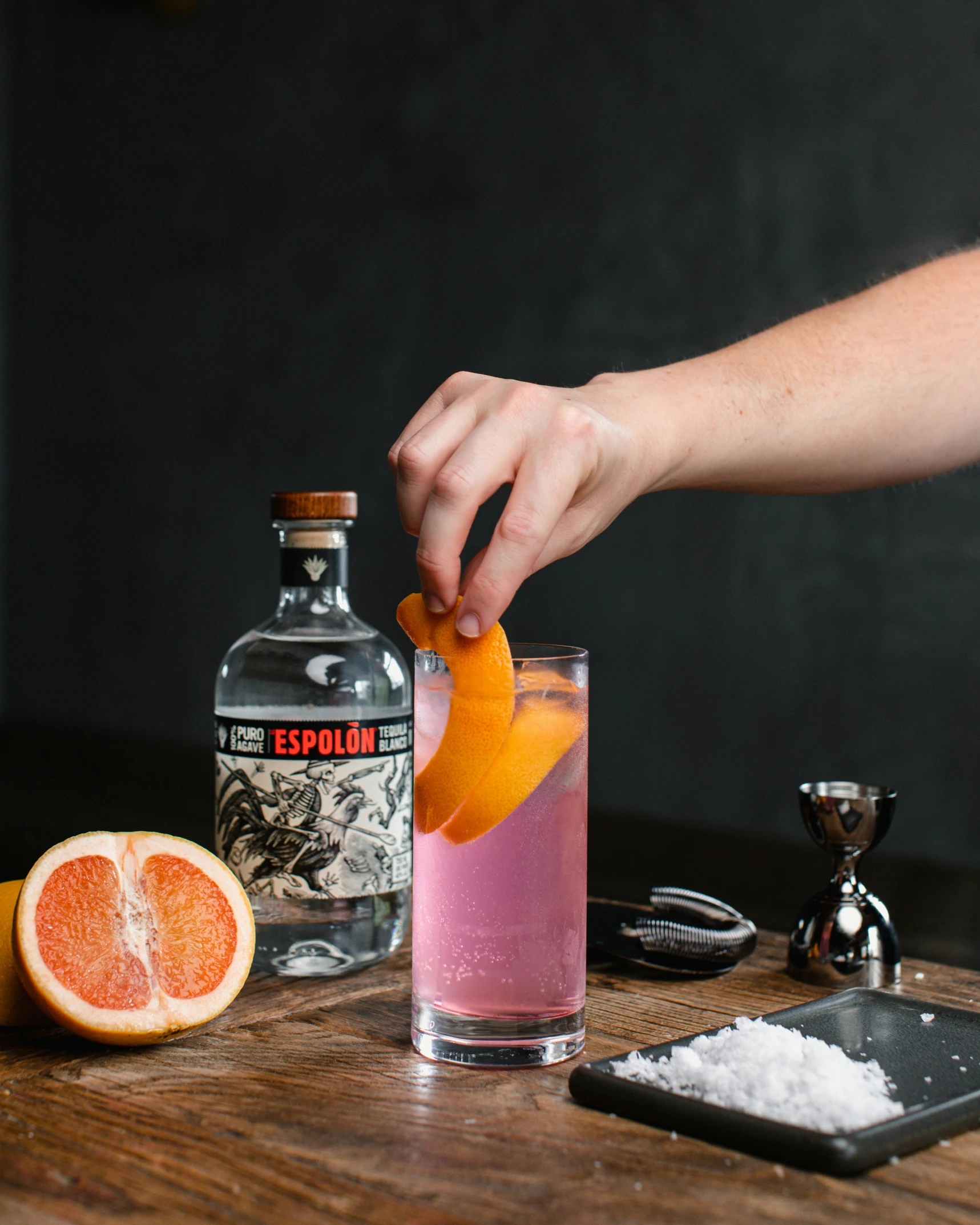 a bartender is preparing a glass of pink lemonade