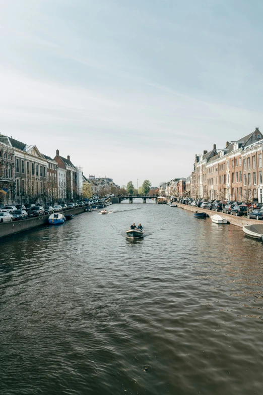 a boat traveling down a canal next to tall buildings