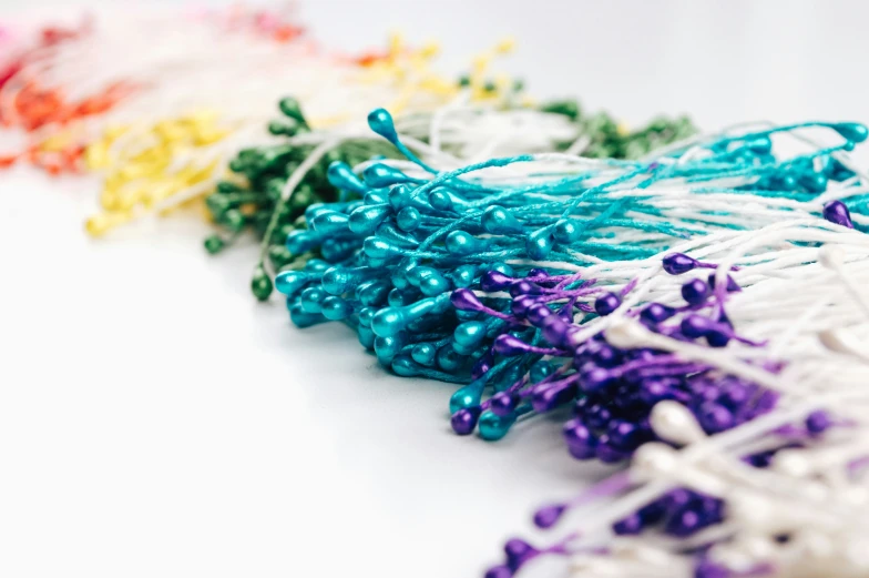 a table filled with different colored string and beads