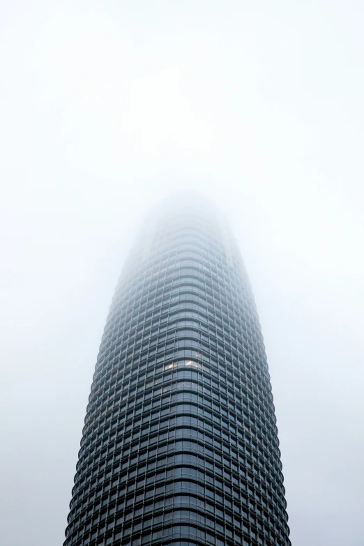 the top of a large building covered in fog