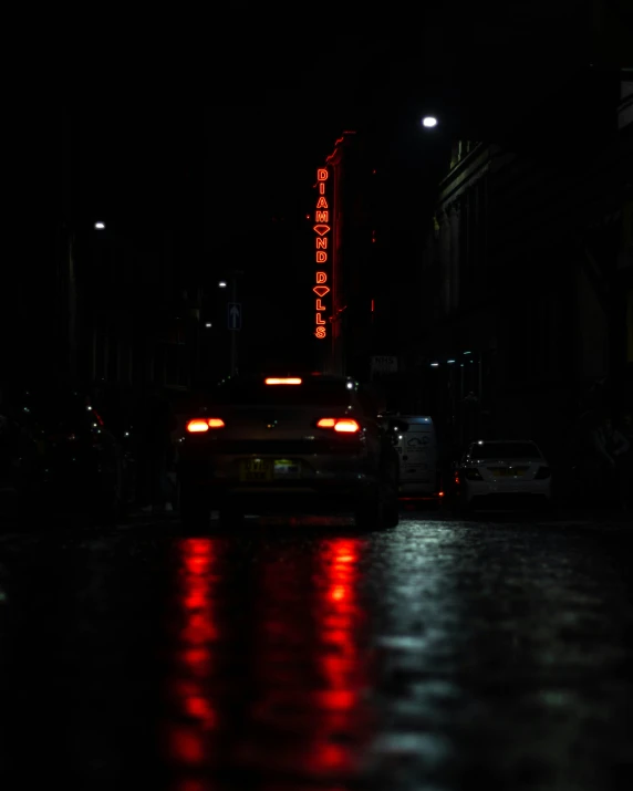 cars in the rain on a dark street at night