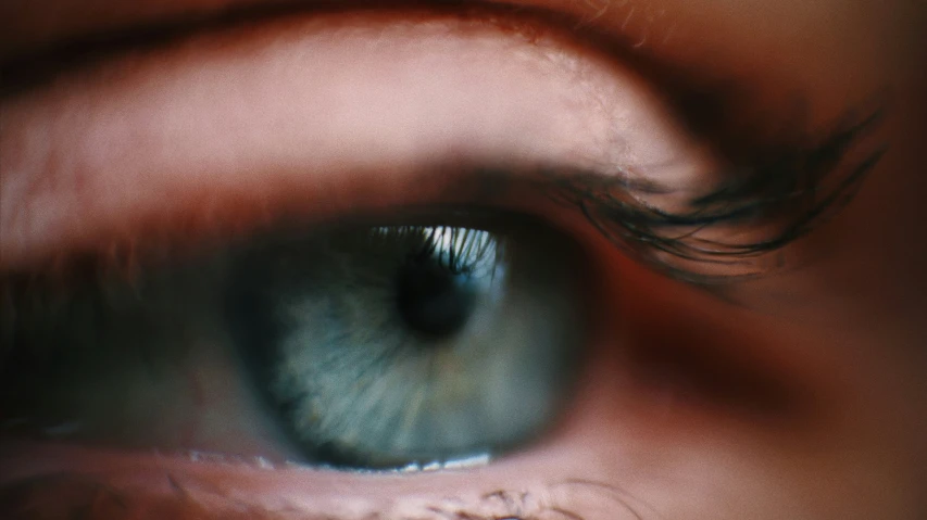 a close up of an eye with a blue - green iris