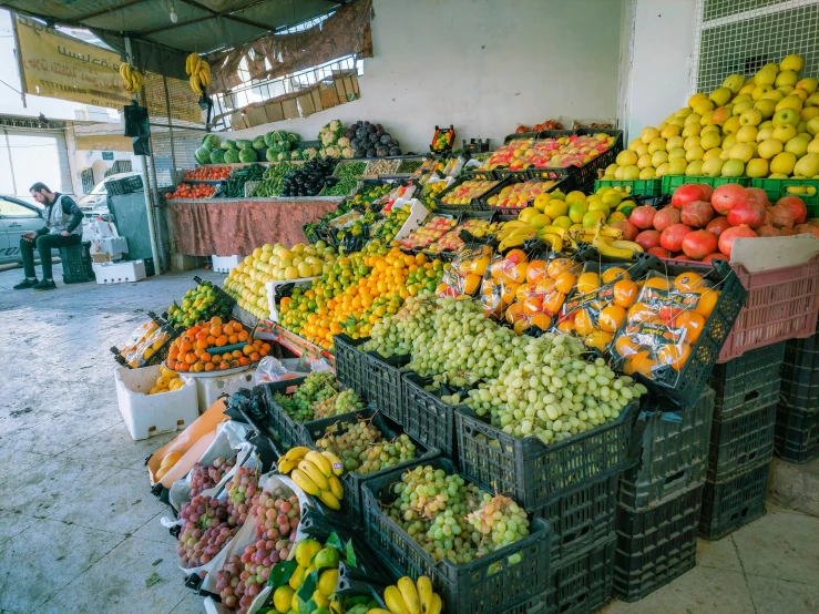 many fruit are on display in baskets and in bins