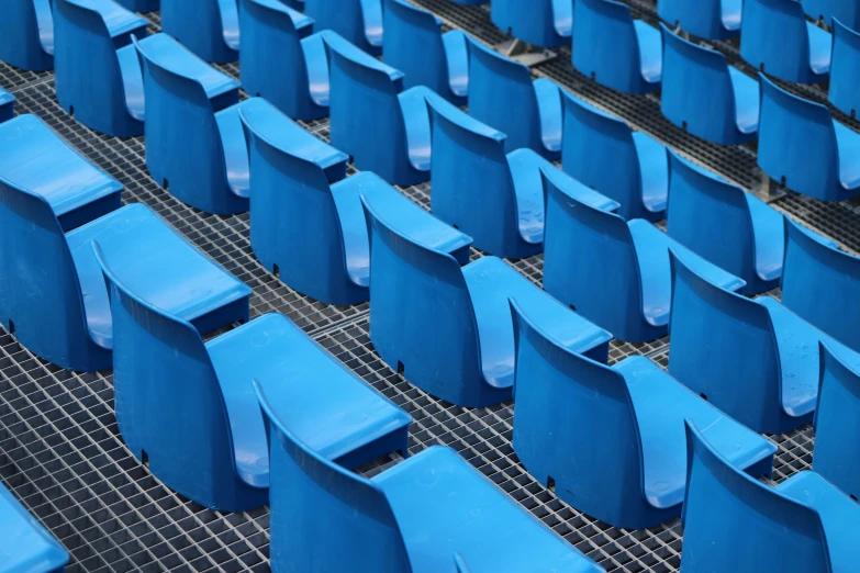 chairs with blue linings sit in rows on a metal rack