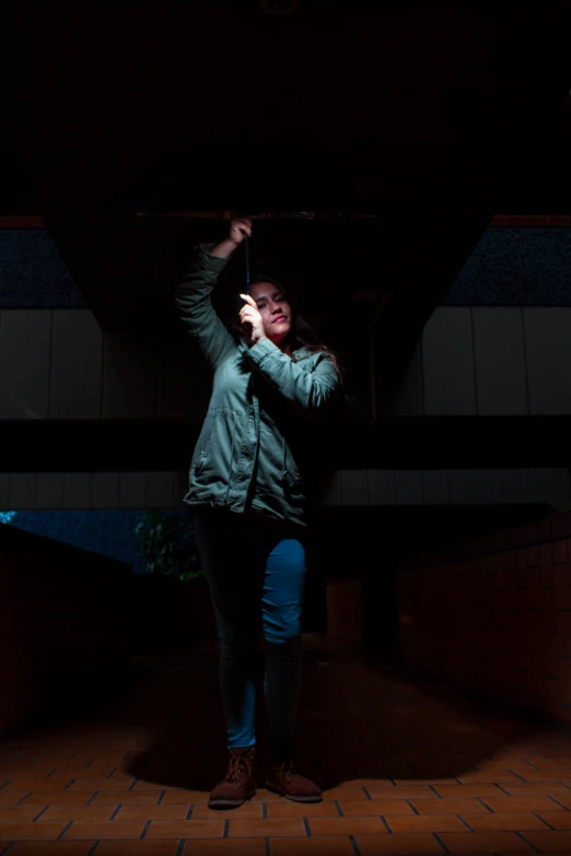 a woman standing inside of a dark building holding an umbrella