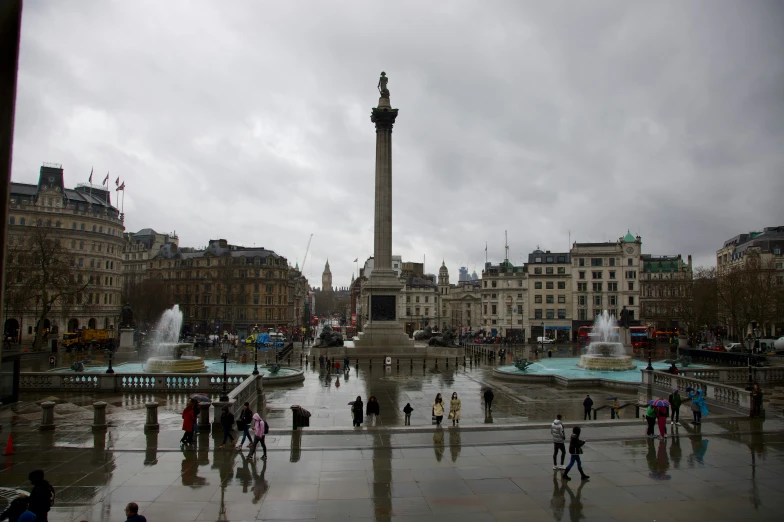 there are people standing in front of a building with a fountain