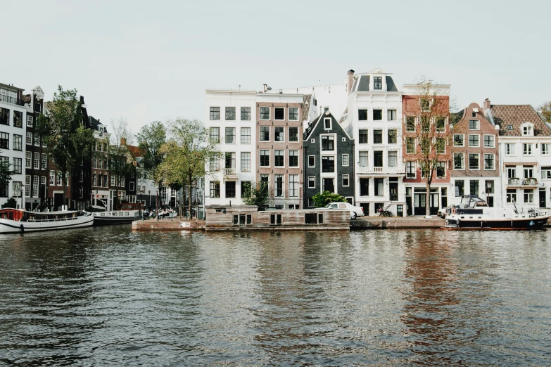 a canal with buildings on the edge of it and boats docked on the other side