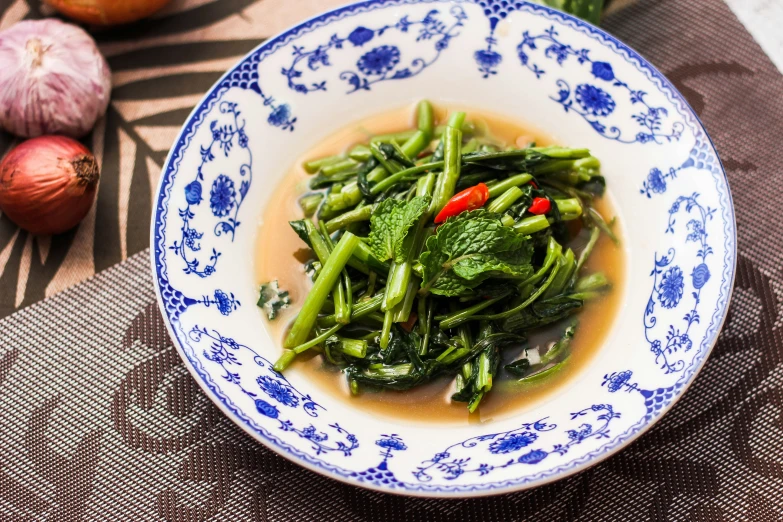 green vegetable with sauce and garlic on tablecloth