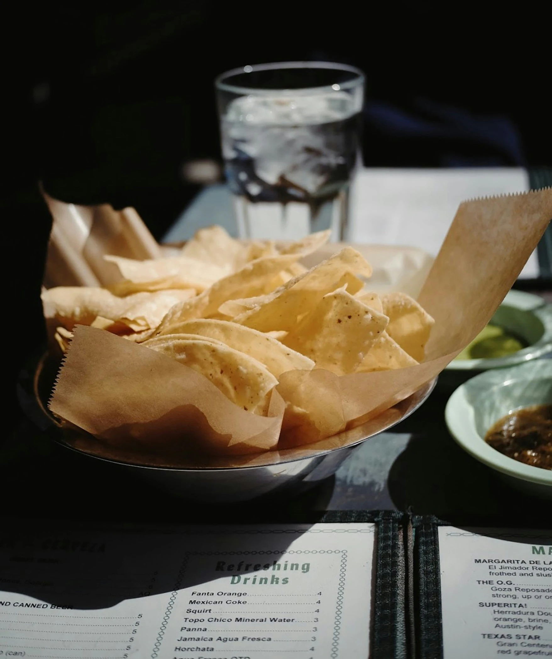 there is a plate full of chips and two glasses of water