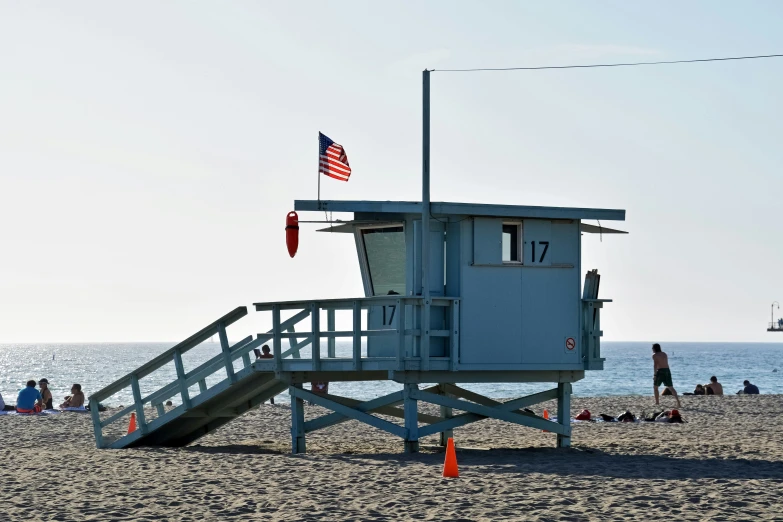 lifeguard tower, steps lead to a small white flag on an ocean beach