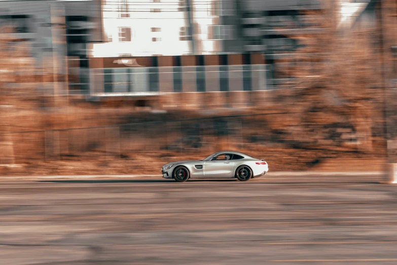 a white sports car driving down the street