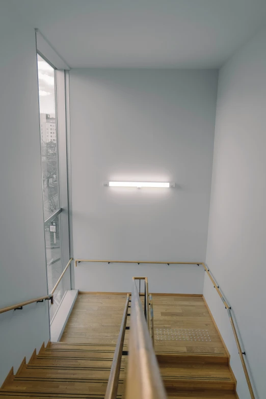 a staircase in an empty room with light from the window