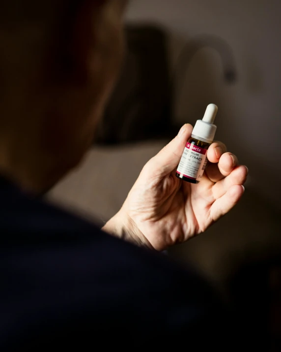 an up close po of a person holding a medicine bottle