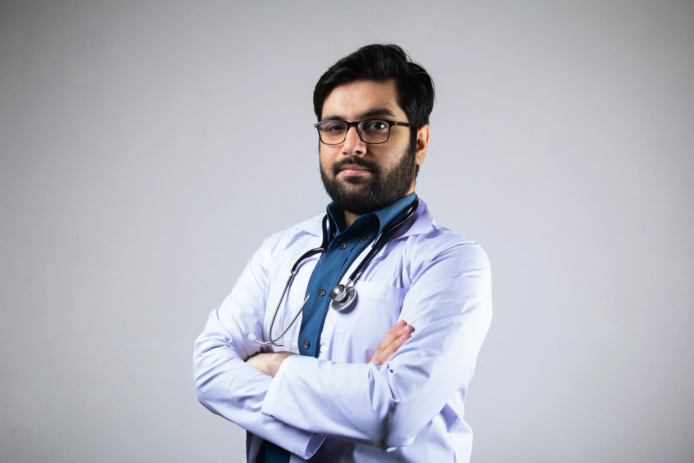 a man with a stethoscope standing and arms crossed