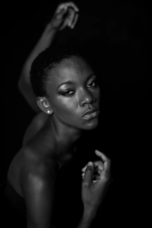 a black and white po of a young woman holding her hands up