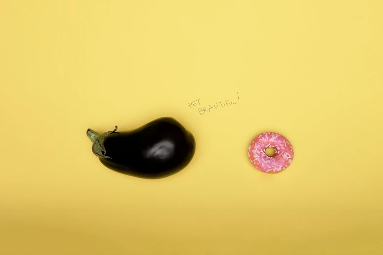 a single donut, a half a pepper and a pepper pepper on a yellow surface