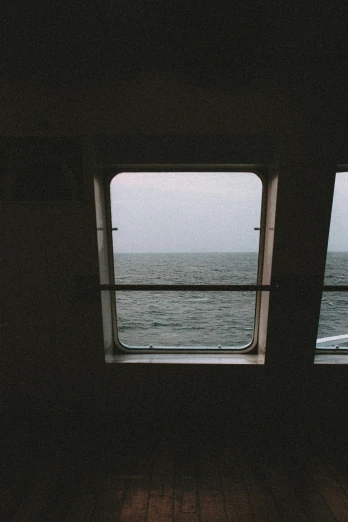 two windows in the middle of a boat looking out at water