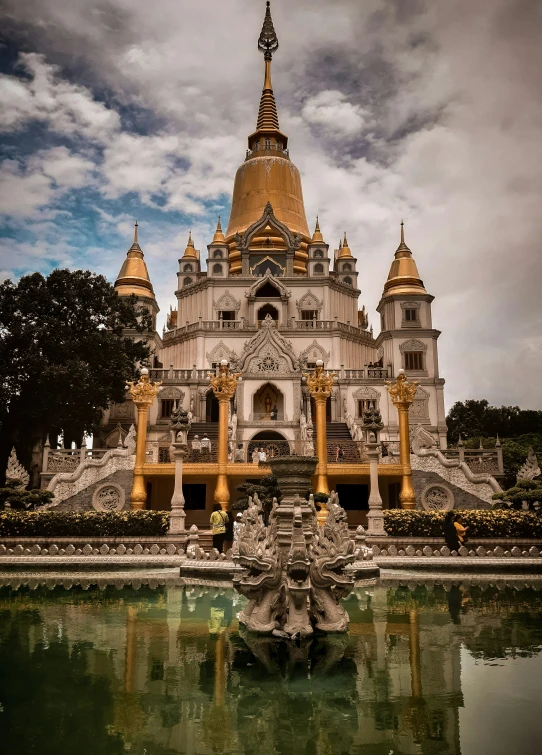 a large white and gold building in the middle of water