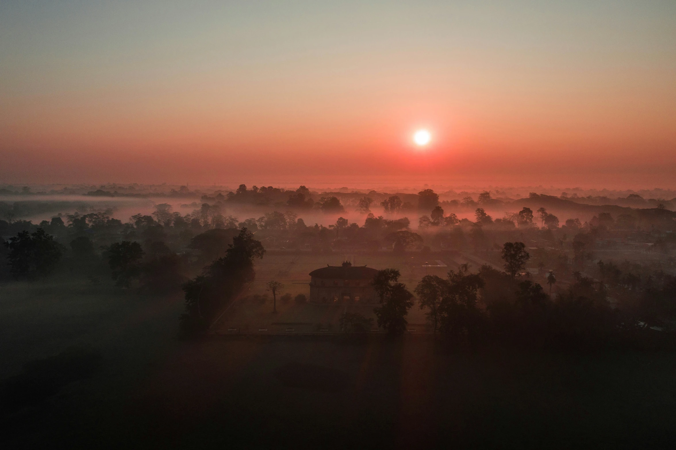 a large area is shown with a sunrise behind it