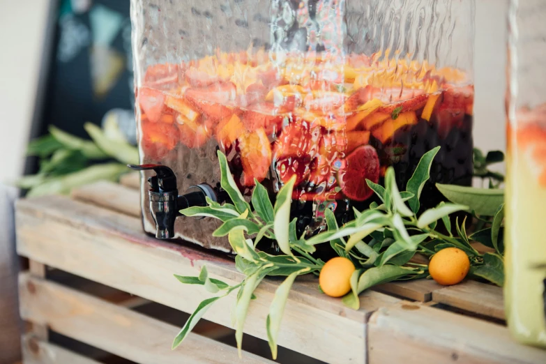 a vase sitting on top of a wooden shelf filled with oranges