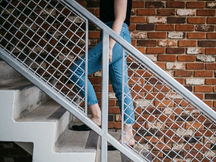 a person standing on top of some steps near a brick wall