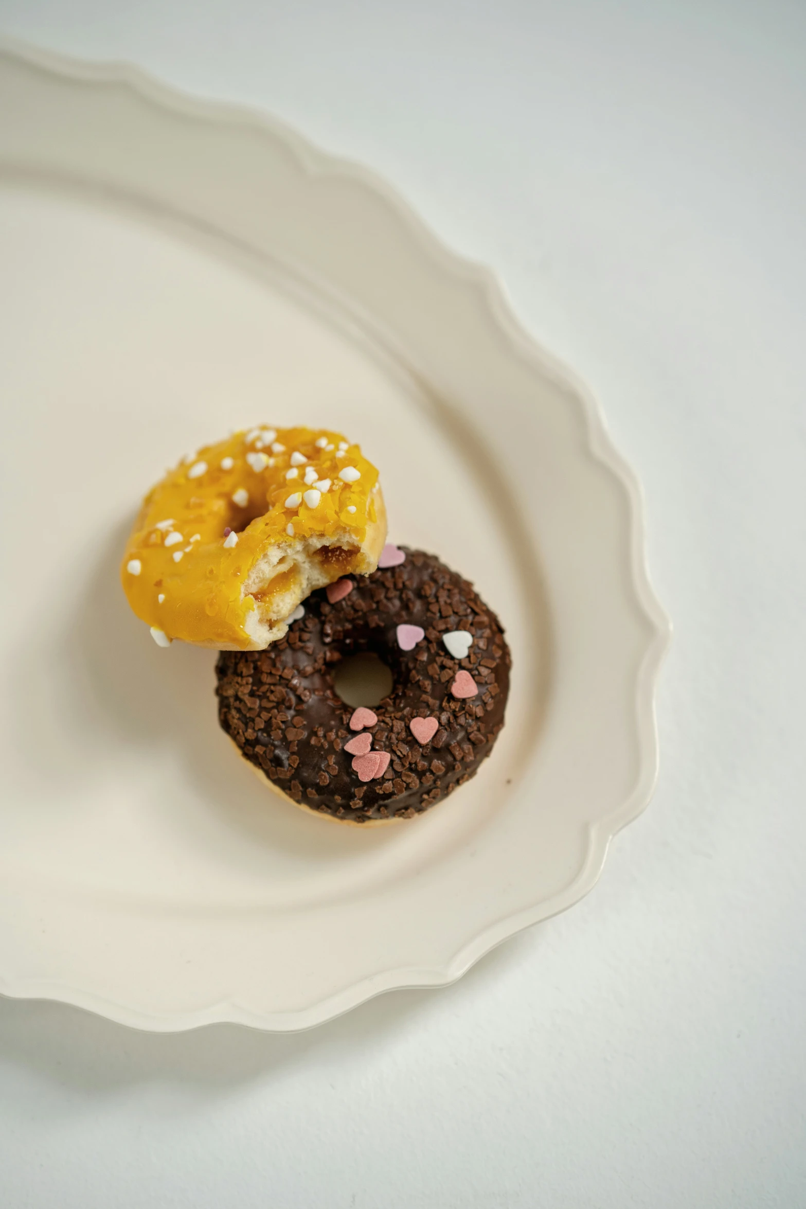 three donuts in a decorative white bowl with sprinkles on them