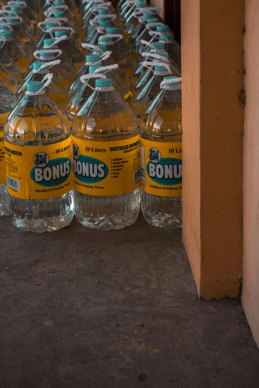 several rows of bottles sit beside each other in a row