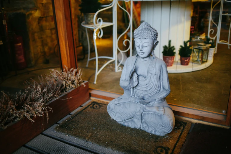 a stone statue sitting on the ground by a store