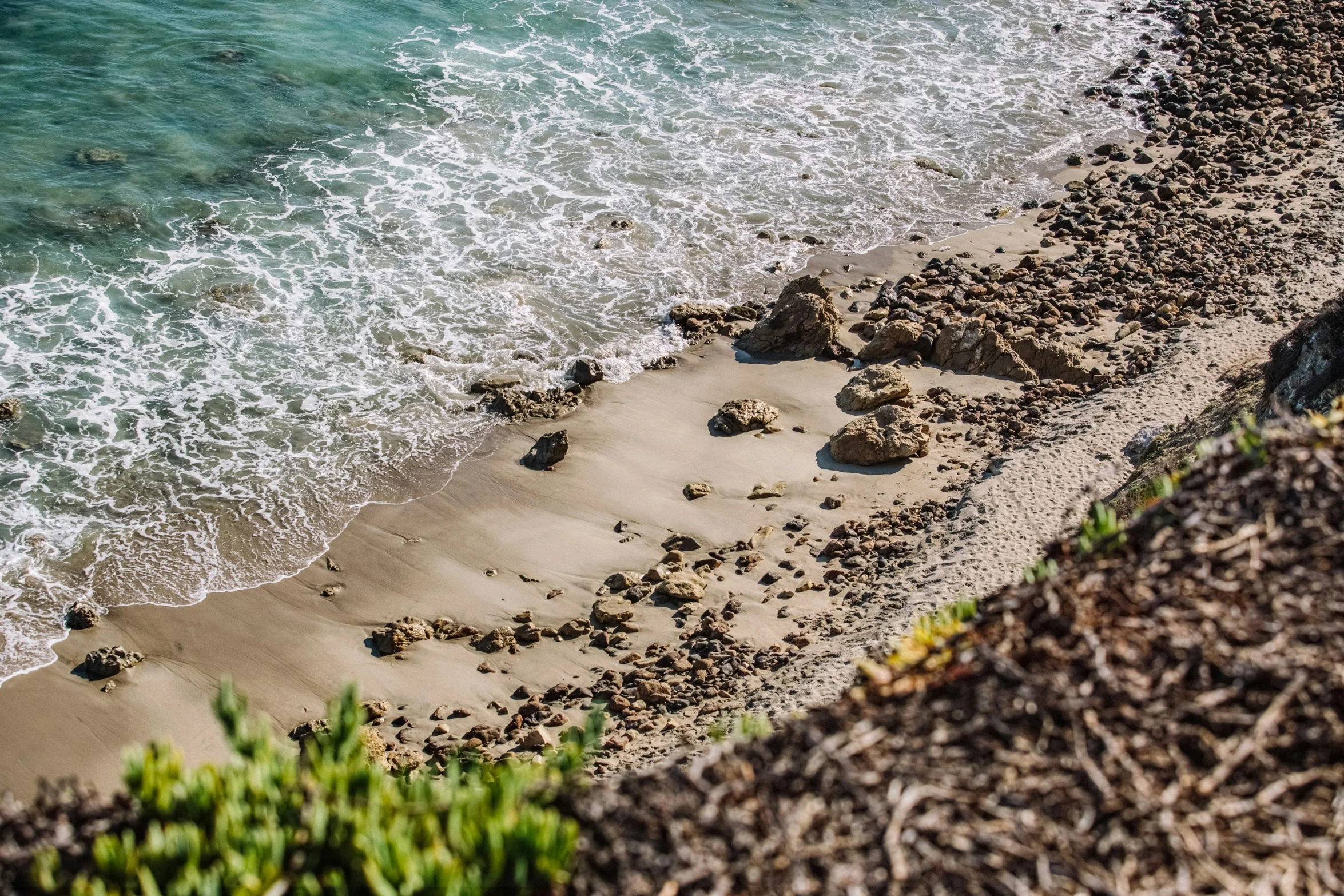 a beach scene of the water and sand