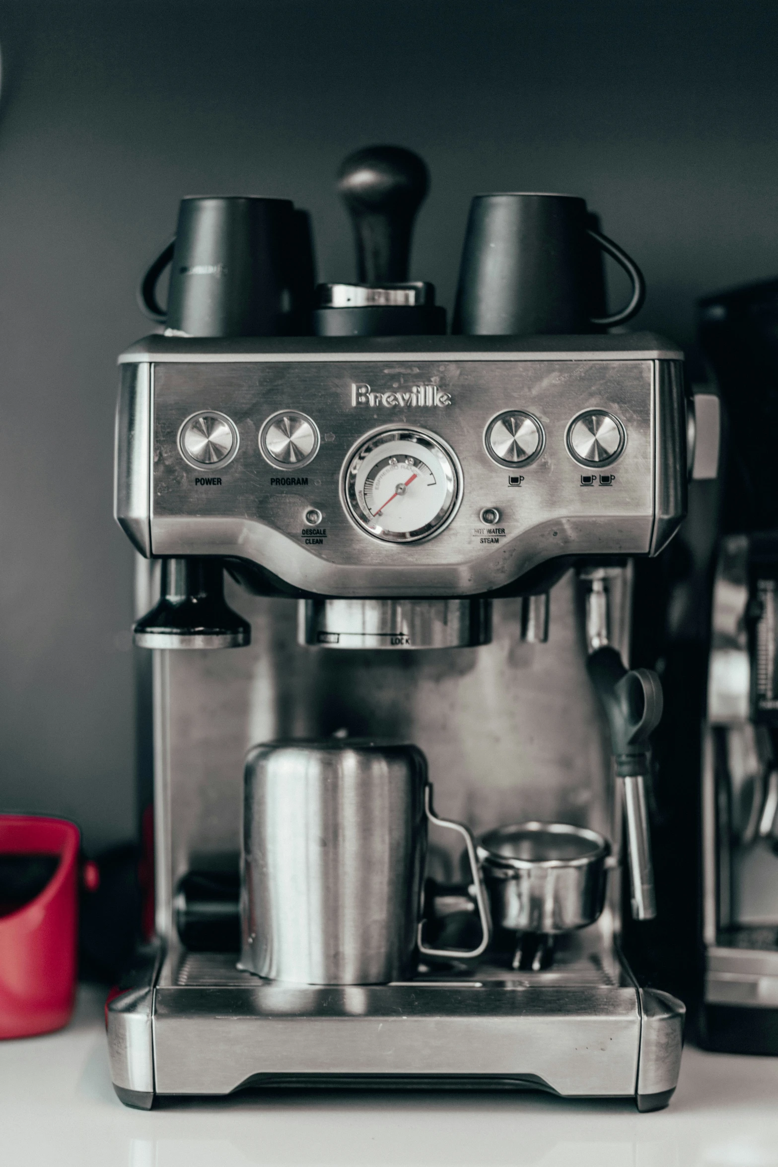 an espresso maker on top of a counter in front of a red box