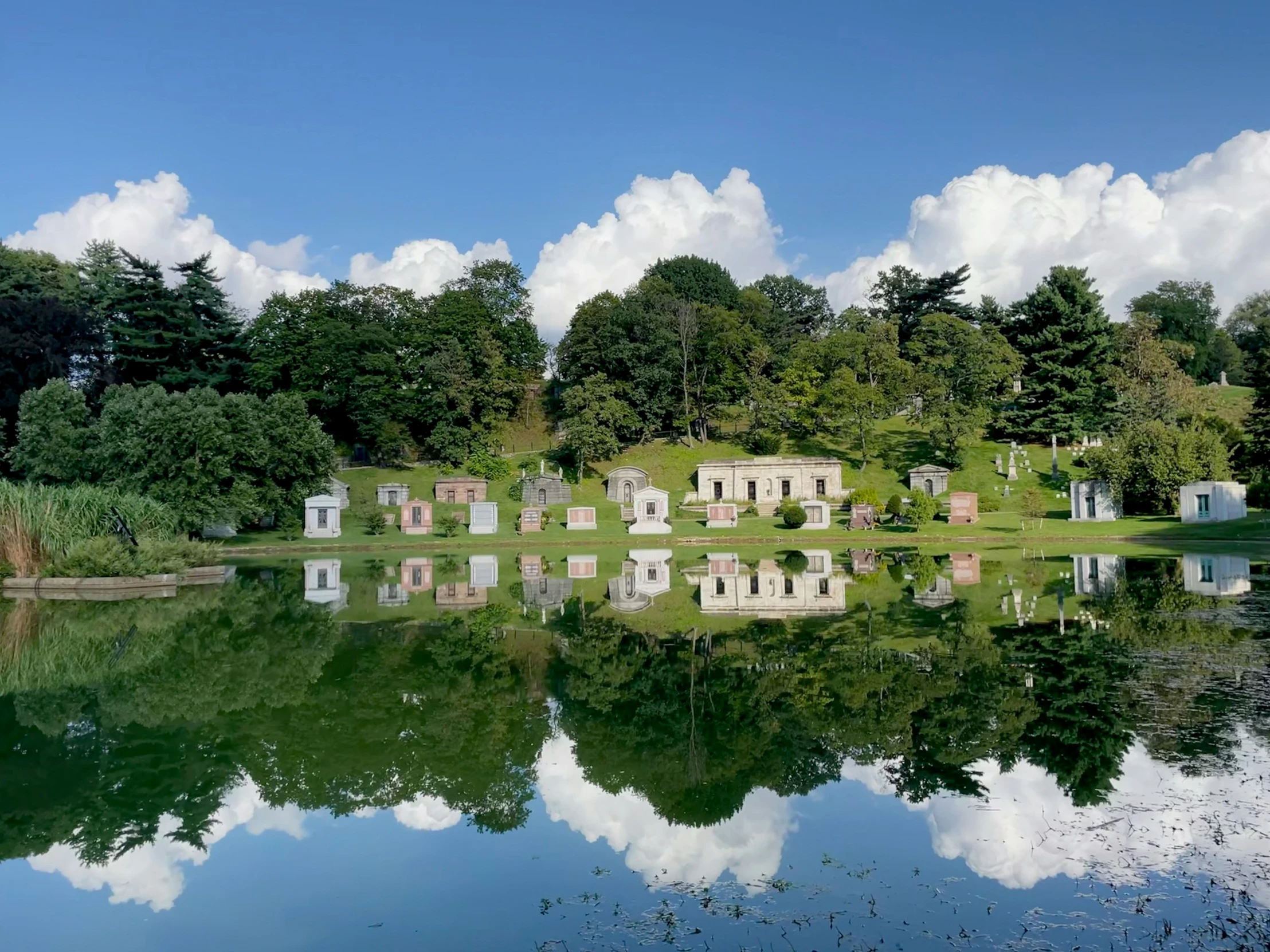 there are many graves and trees around the lake