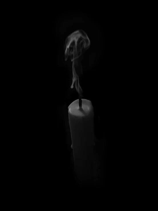 a black and white pograph with a candle that has smoke coming out