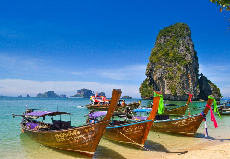 a row of boats with a large island in the background