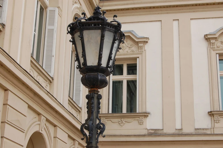 an old fashioned lamp post in front of a building