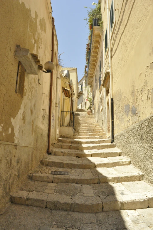 an alley with steps in a village with no people on them